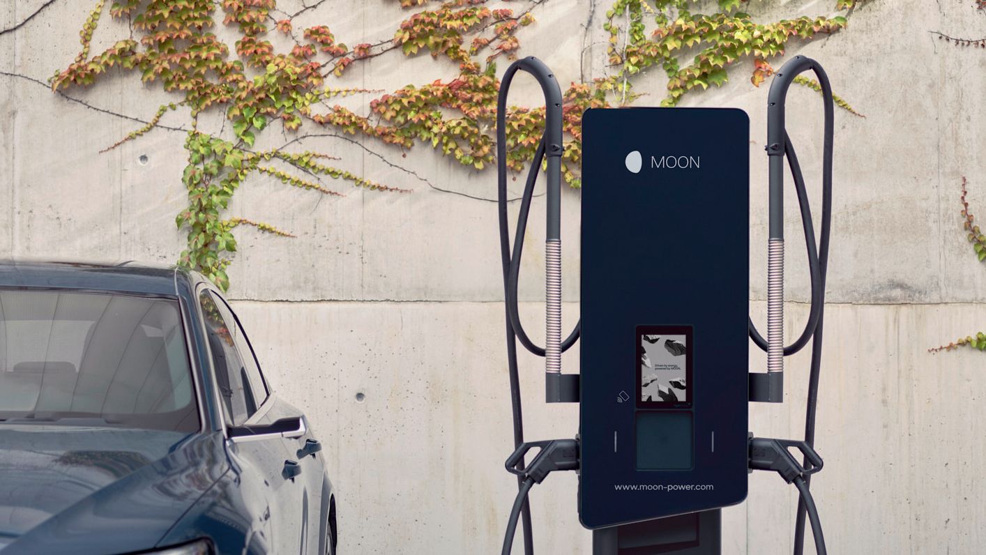 Samochód jest zaparkowany obok stacji ładowania