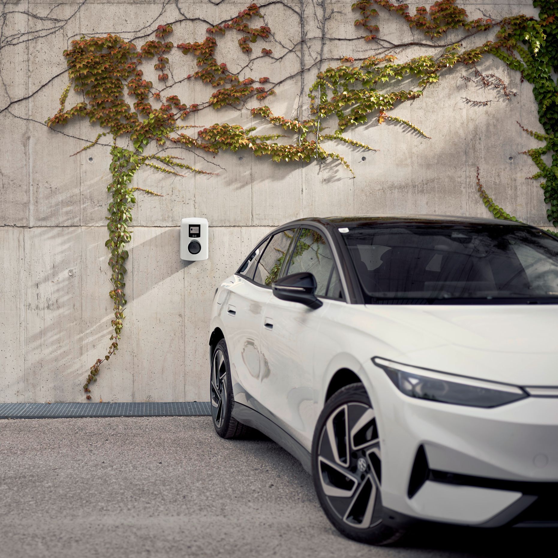 L'auto si trova di fronte a un muro di cemento con wallbox